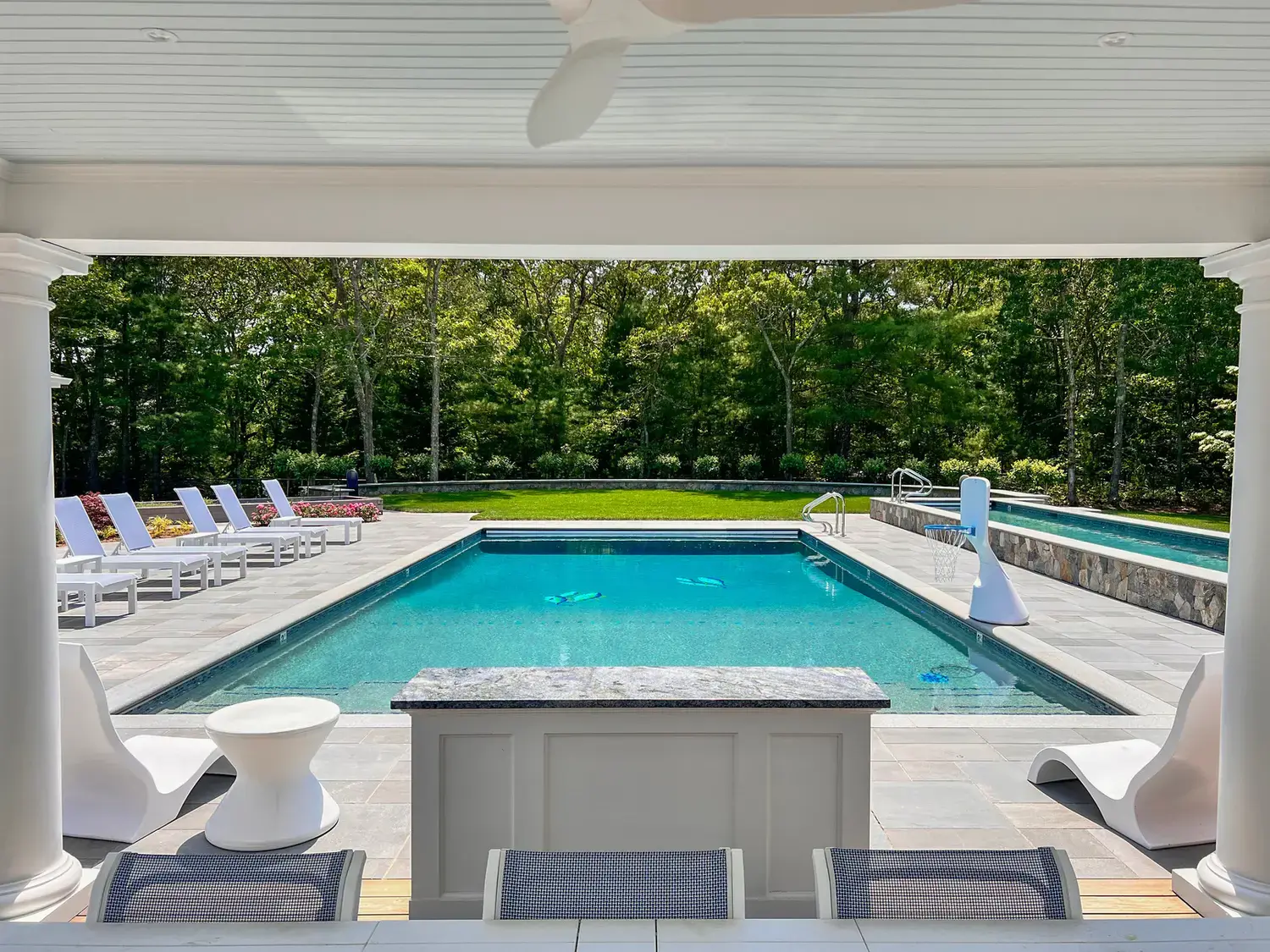 Cool gray Everblue porcelain pavers on a pool deck seen from a covered loggia