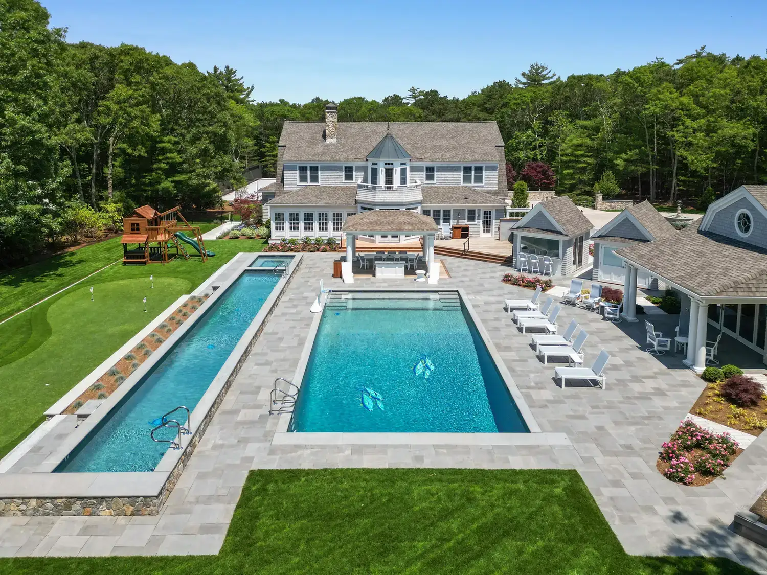 Everblue porcelain pavers around a pool at a shingle-style estate