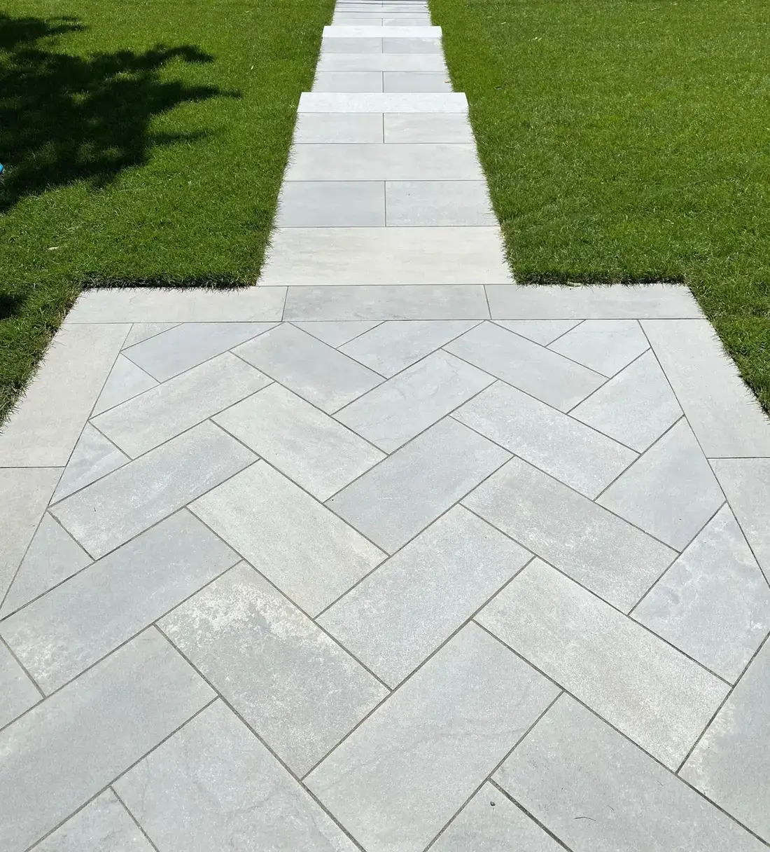 Everblue porcelain pavers in a herringbone pattern with a border course